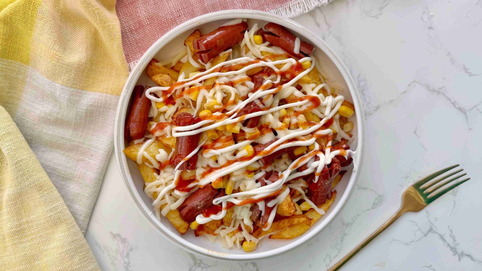 Salchipapas served in a bowl with sauce toppings