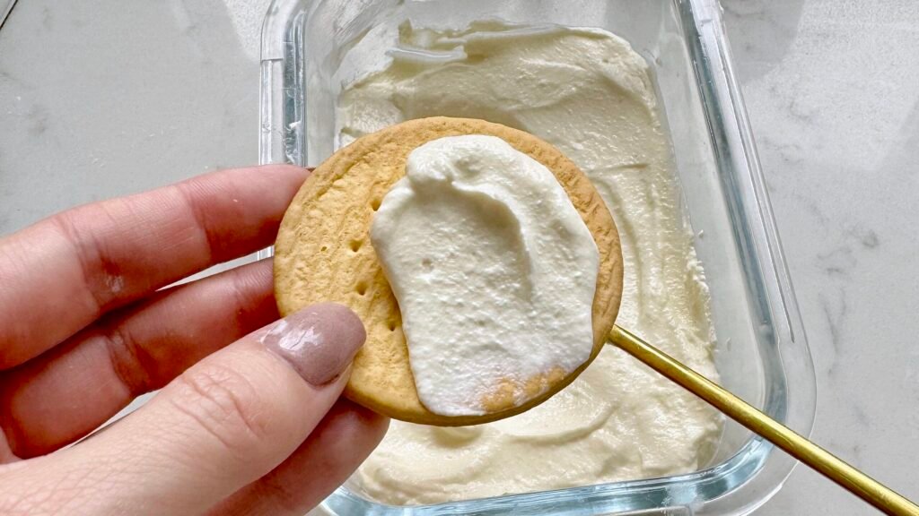 Homemade mascarpone cheese in a white bowl, garnished with fresh herbs, ready to serve as a spread or cooking ingredient.