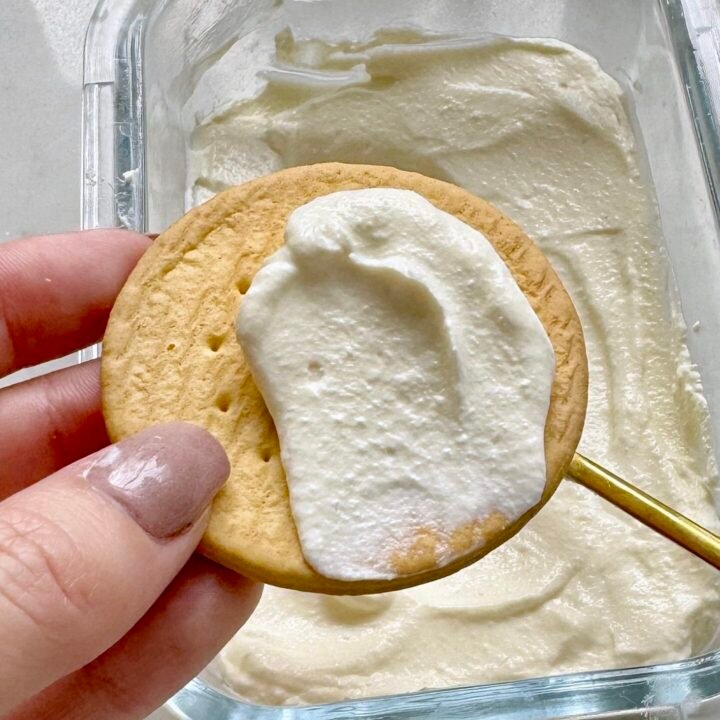 Homemade mascarpone cheese in a white bowl, garnished with fresh herbs, ready to serve as a spread or cooking ingredient.