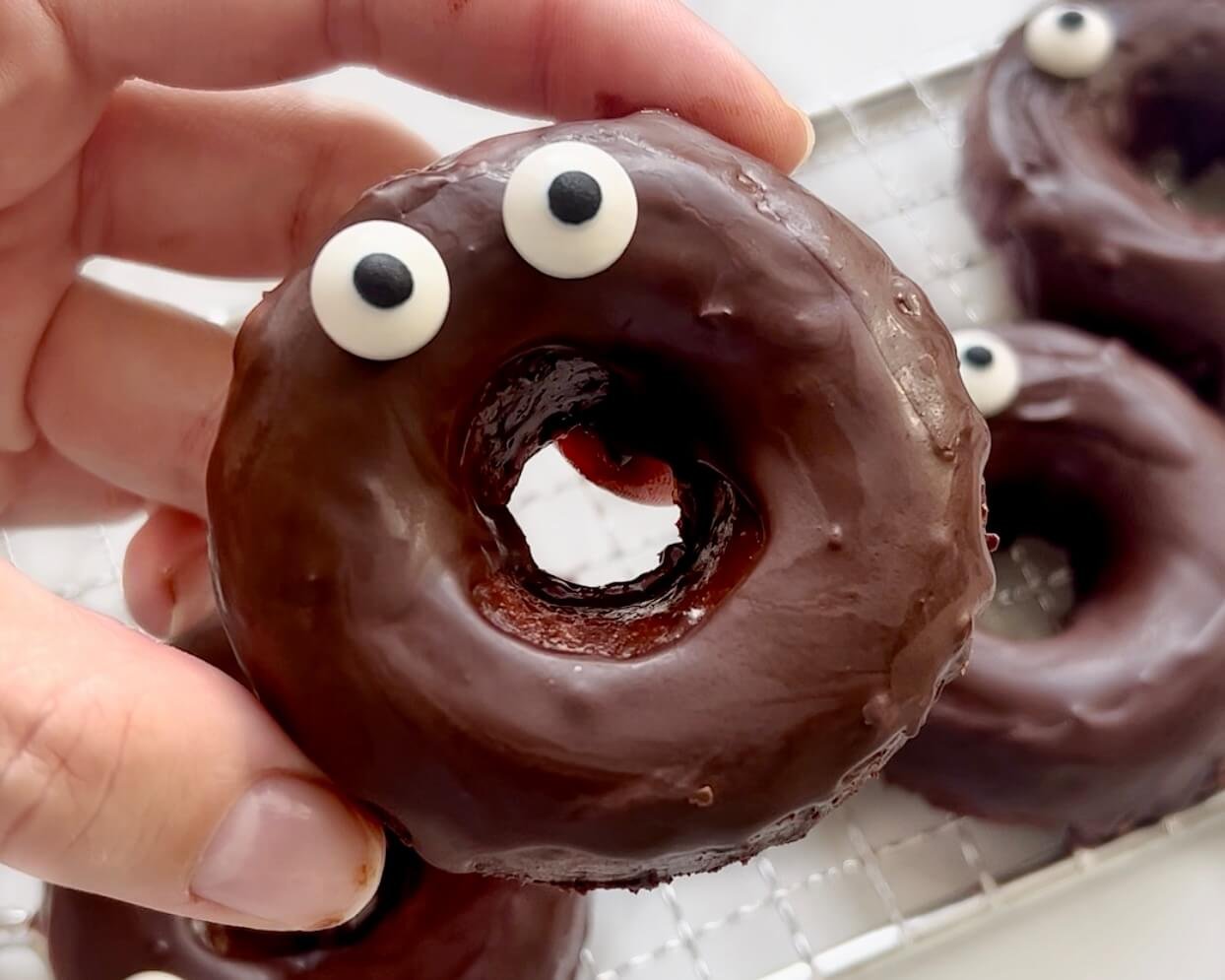 Chocolate Apple Doughnuts, one held in hand