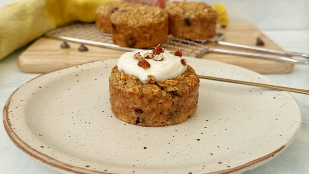 Freshly baked banana bread breakfast muffins topped with Skyr and chopped nuts, served on a rustic wooden board.