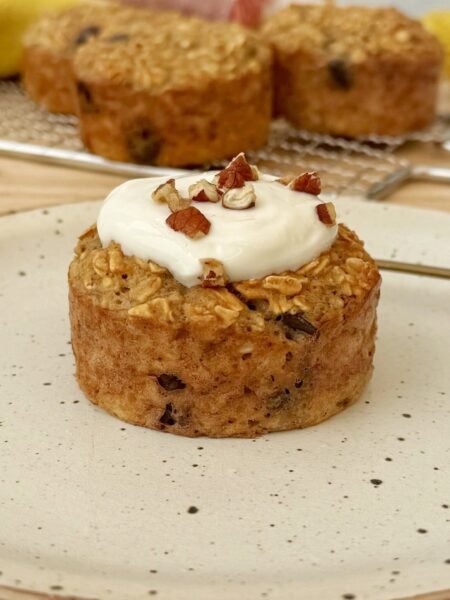 Freshly baked banana bread breakfast muffins topped with Skyr and chopped nuts, served on a rustic wooden board.
