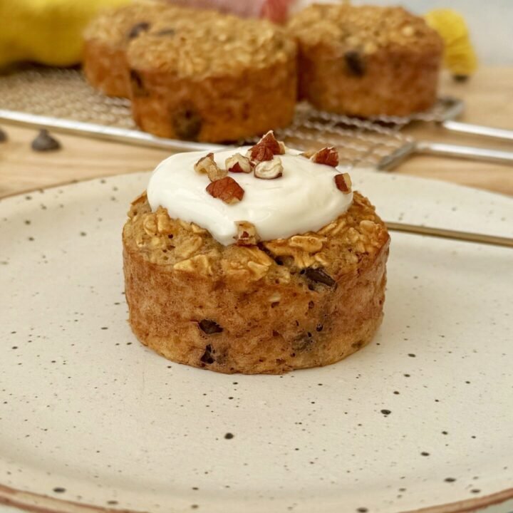 Freshly baked banana bread breakfast muffins topped with Skyr and chopped nuts, served on a rustic wooden board.