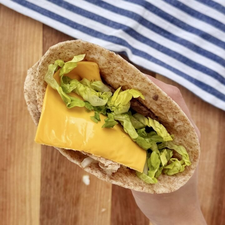 a person holding a taco