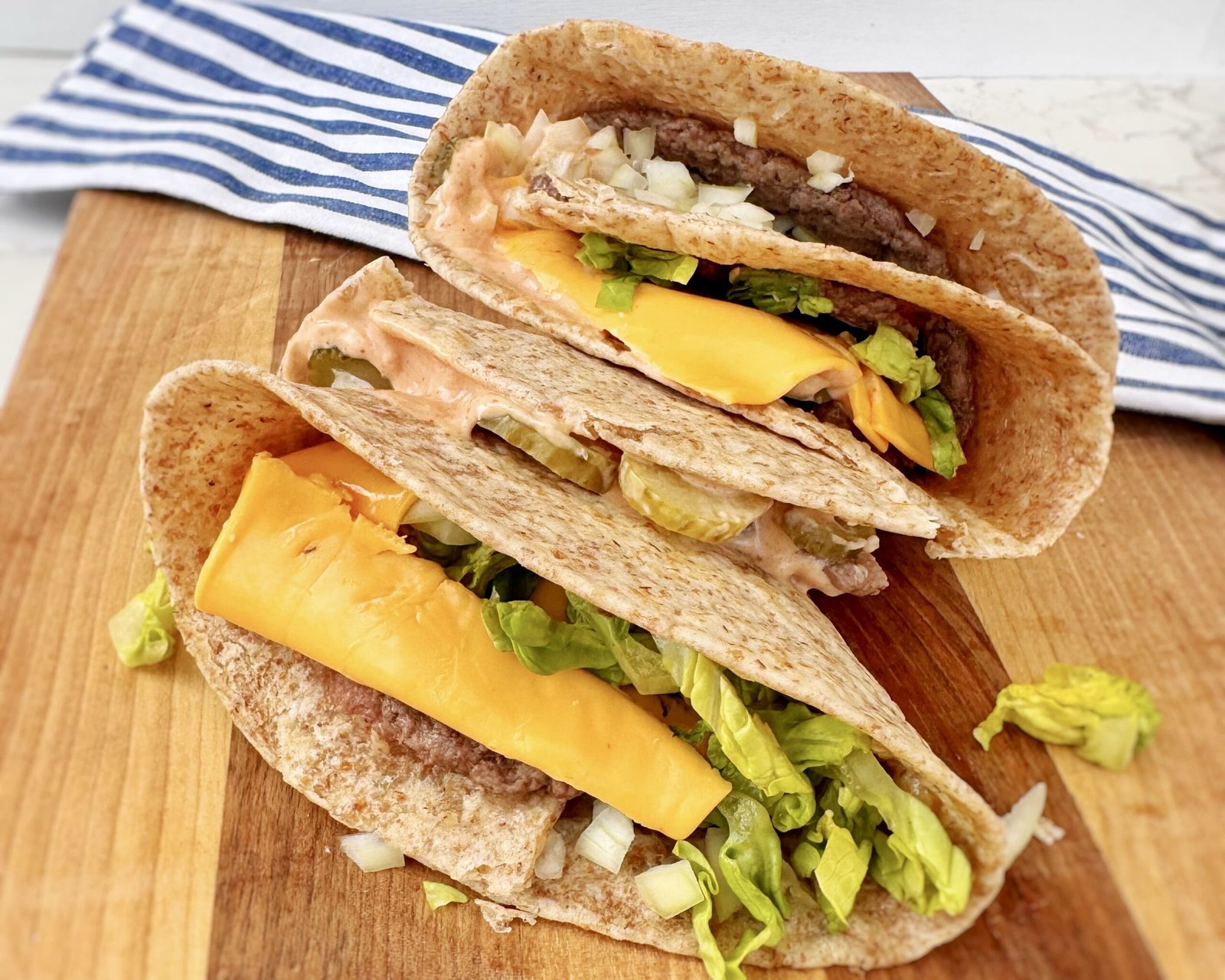 a group of tacos on a wood surface. Big Mac Smash Wrap