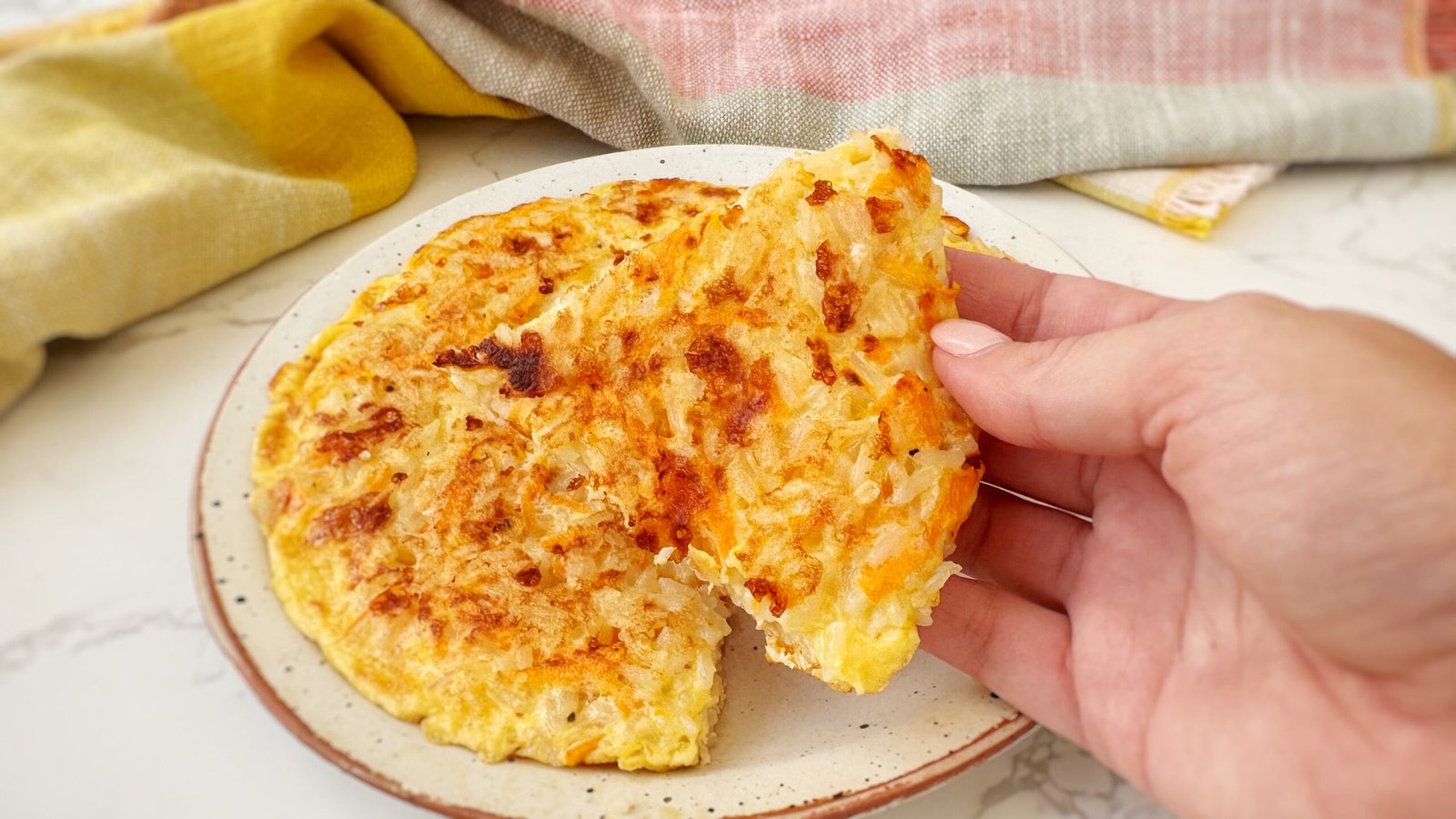 A golden-brown Crispy Rice and Carrot Pie sliced into wedges on a plate, with visible flecks of carrot and melted cheese.