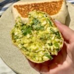 Chopped Egg Salad Wraps vut in half and held in hand