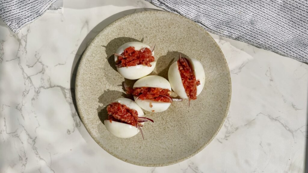 A plate with hard boiled eggs with a pepper relish called kosua ne meko