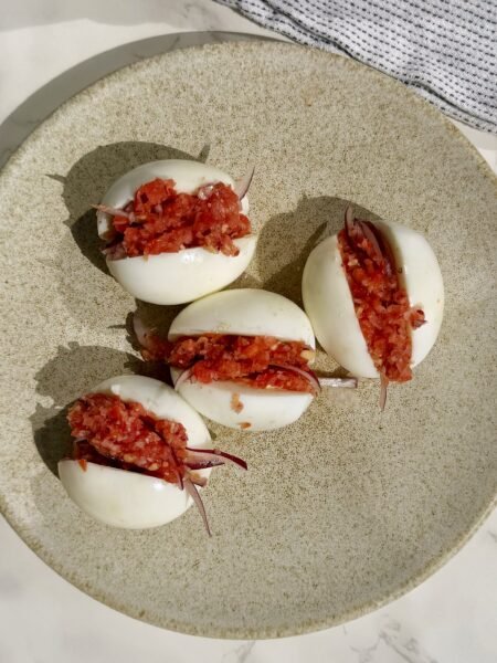 A plate with hard boiled eggs with a pepper relish called kosua ne meko