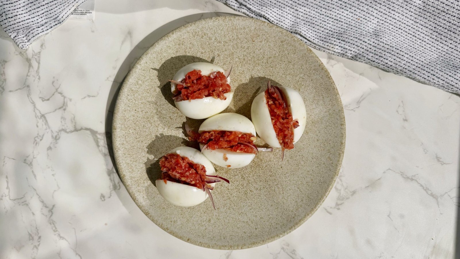 A plate with hard boiled eggs with a pepper relish called kosua ne meko