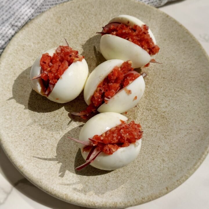 A plate with hard boiled eggs with a pepper relish called kosua ne meko