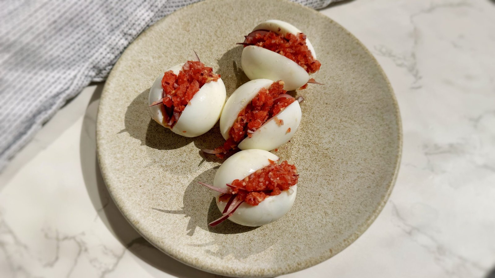 A plate with hard boiled eggs with a pepper relish called kosua ne meko