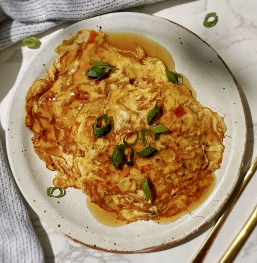 A plate with two egg pancakes containing mince pork and vegetables, called Healthy Minced Pork Egg Foo Young
