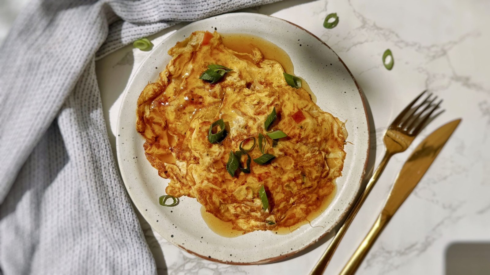 A plate with two egg pancakes containing mince pork and vegetables, called Healthy Minced Pork Egg Foo Young