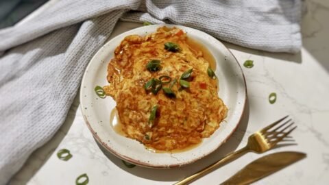 A plate with two egg pancakes containing mince pork and vegetables, called Healthy Minced Pork Egg Foo Young