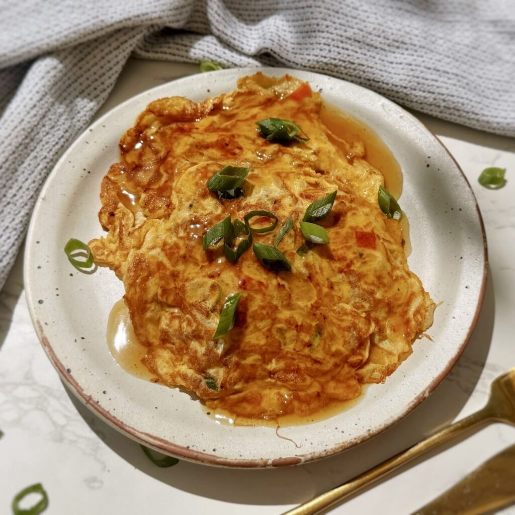 A plate with two egg pancakes containing mince pork and vegetables, called Healthy Minced Pork Egg Foo Young
