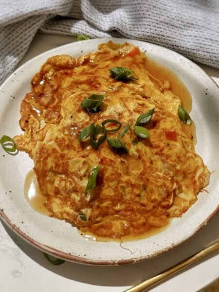 A plate with two egg pancakes containing mince pork and vegetables, called Healthy Minced Pork Egg Foo Young