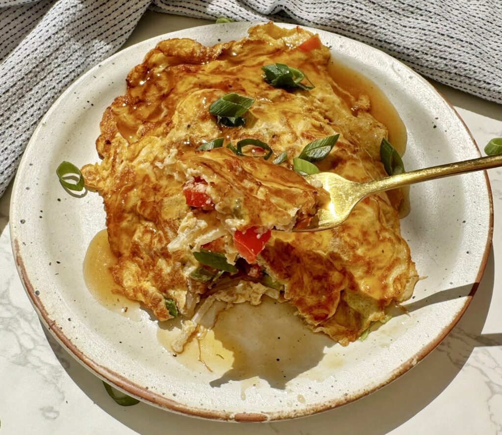 A plate with two egg pancakes containing mince pork and vegetables, called Healthy Minced Pork Egg Foo Young