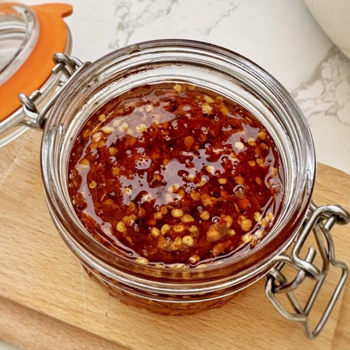 Glass Jar containing Homemade Hot Honey with chilli flakes