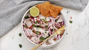 Authentic Peruvian Ceviche with lime-cured fish, red onion, chilli slices, coriander, served with sweet potato and corn