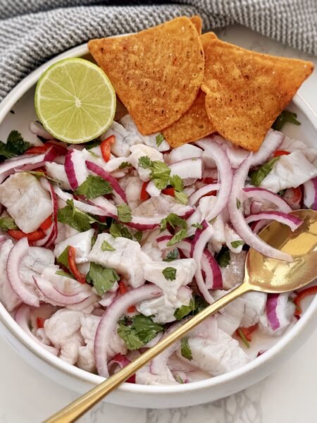 Authentic Peruvian Ceviche with lime-cured fish, red onion, chilli slices, coriander, served with sweet potato and corn