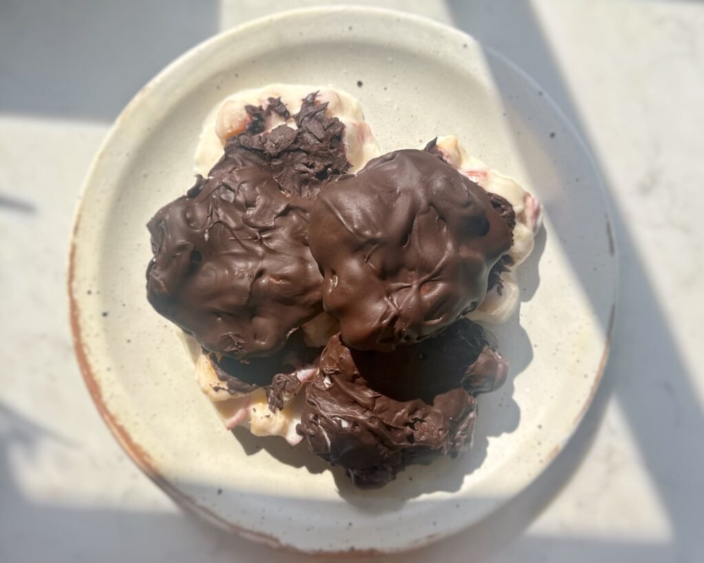 Homemade Peach Clusters with yoghurt and dark chocolate on a tray, chilled and ready to serve