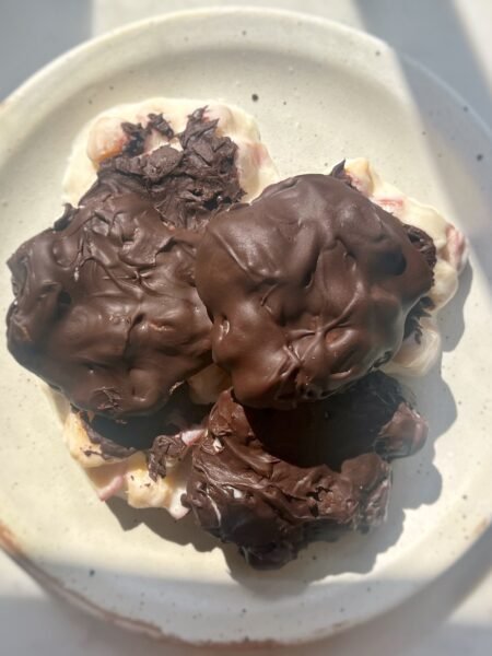 Homemade Peach Clusters with yoghurt and dark chocolate on a tray, chilled and ready to serve