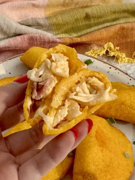 Golden, air-fried Egg Breakfast Empanadas filled with scrambled eggs, ham, and cheese on a serving plate.