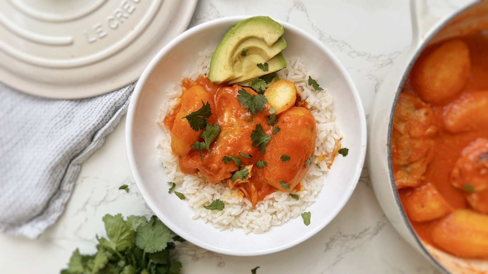 A comforting bowl of Pollo Sudado (Colombian Stewed Chicken) served with potatoes, fresh cilantro, and white rice