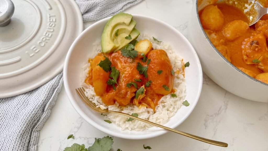 A comforting bowl of Pollo Sudado (Colombian Stewed Chicken) served with potatoes, fresh cilantro, and white rice
