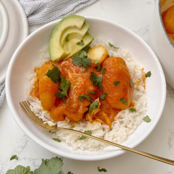 A comforting bowl of Pollo Sudado (Colombian Stewed Chicken) served with potatoes, fresh cilantro, and white rice