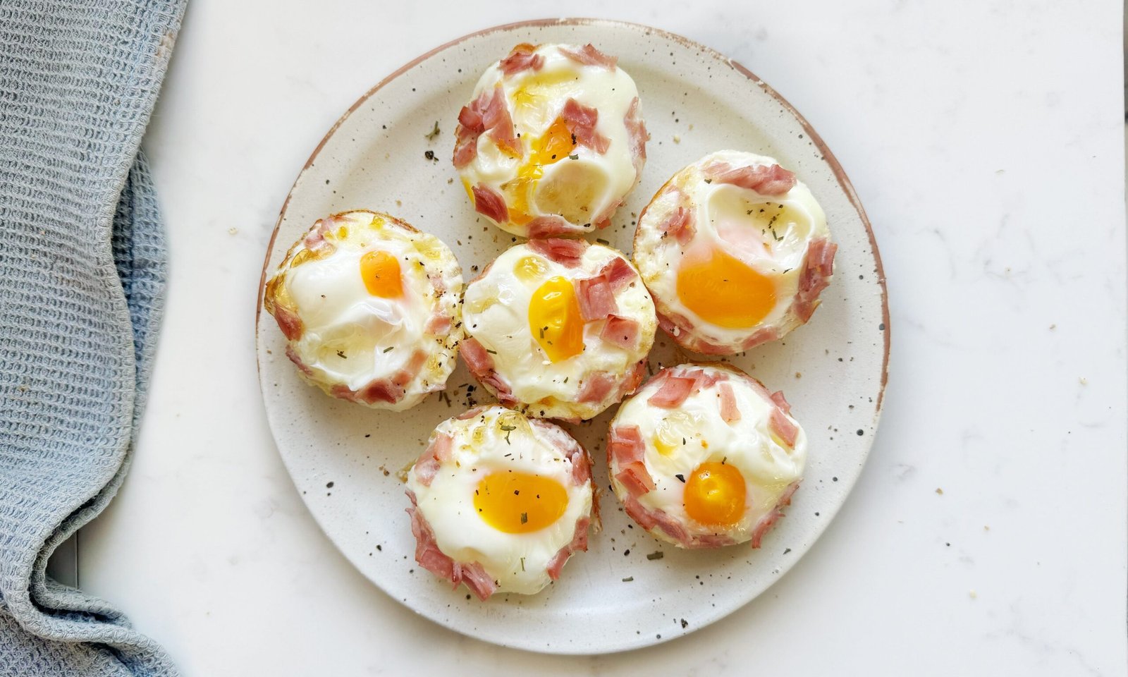 Golden Cheesy Ham Egg Bites baked in a muffin tin – a high-protein, low-carb breakfast or snack option.