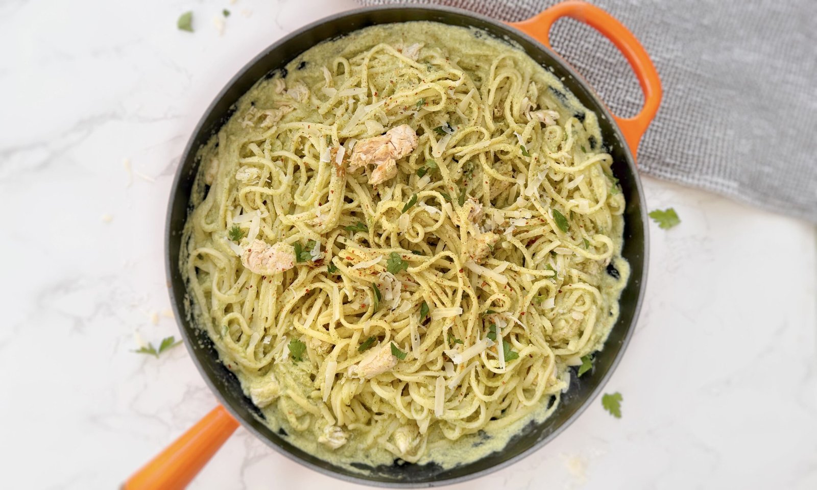 Creamy zucchini and chicken pasta served in a white bowl with fresh parsley garnish