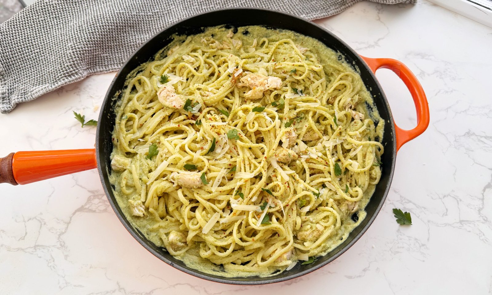Creamy zucchini and chicken pasta served in a white bowl with fresh parsley garnish