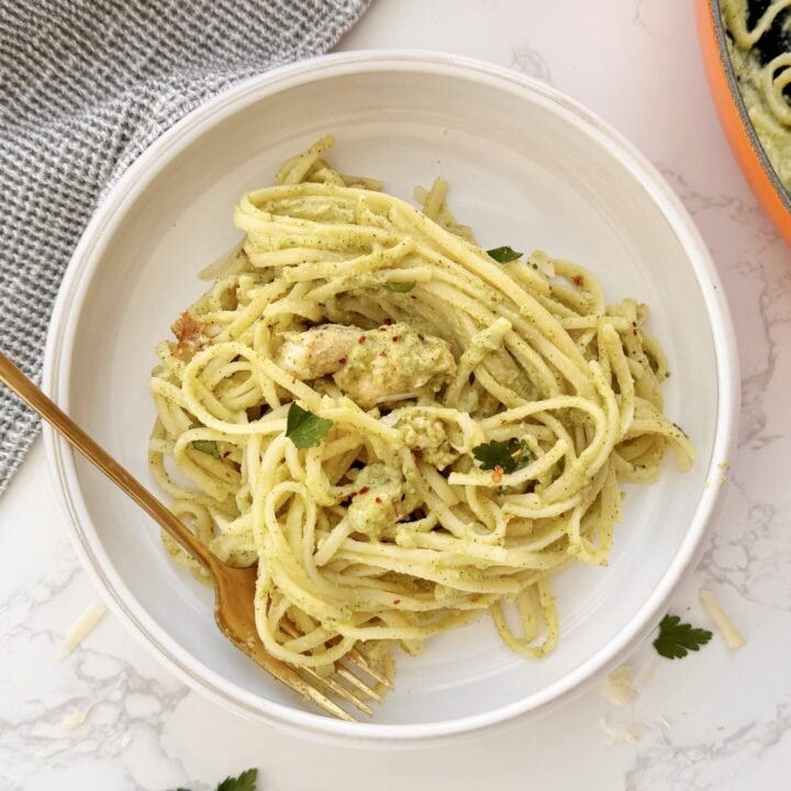 Creamy zucchini and chicken pasta served in a white bowl with fresh parsley garnish