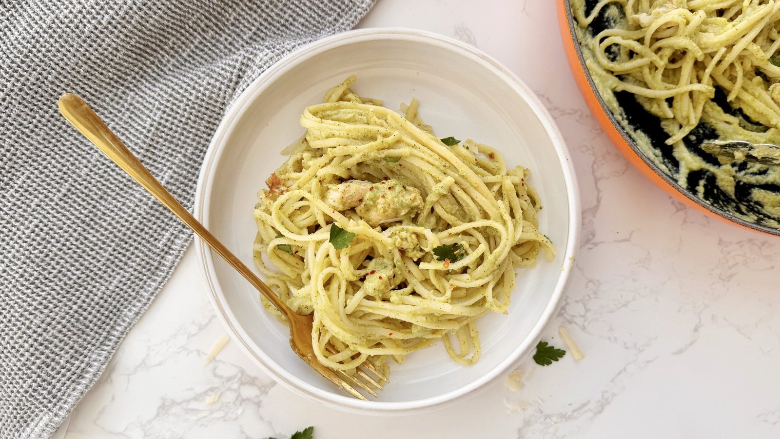 Creamy zucchini and chicken pasta served in a white bowl with fresh parsley garnish