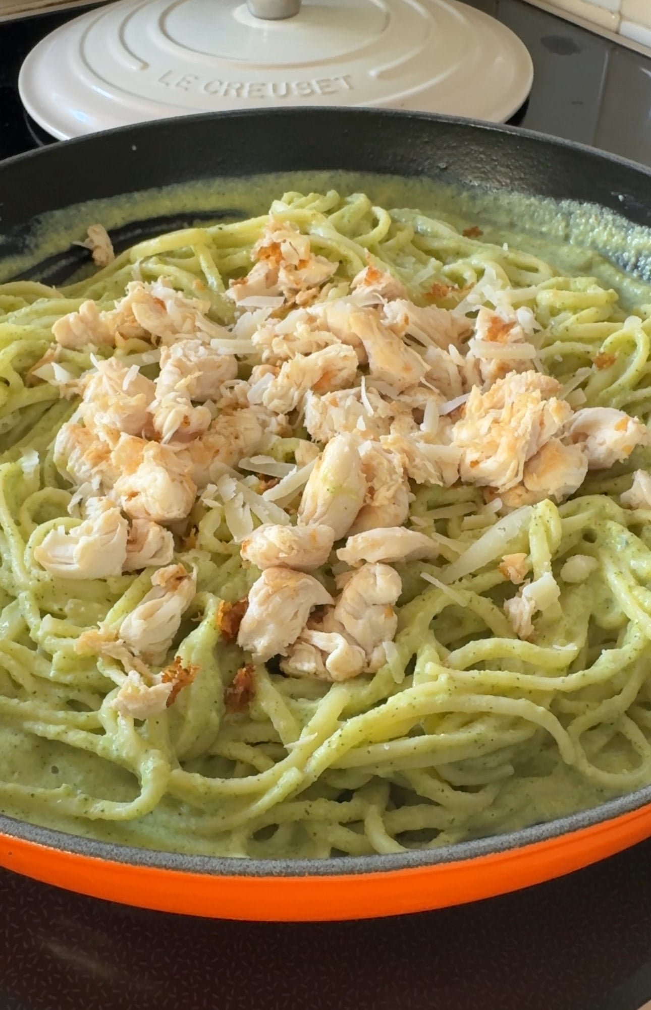 Creamy zucchini and chicken pasta served in a white bowl with fresh parsley garnish