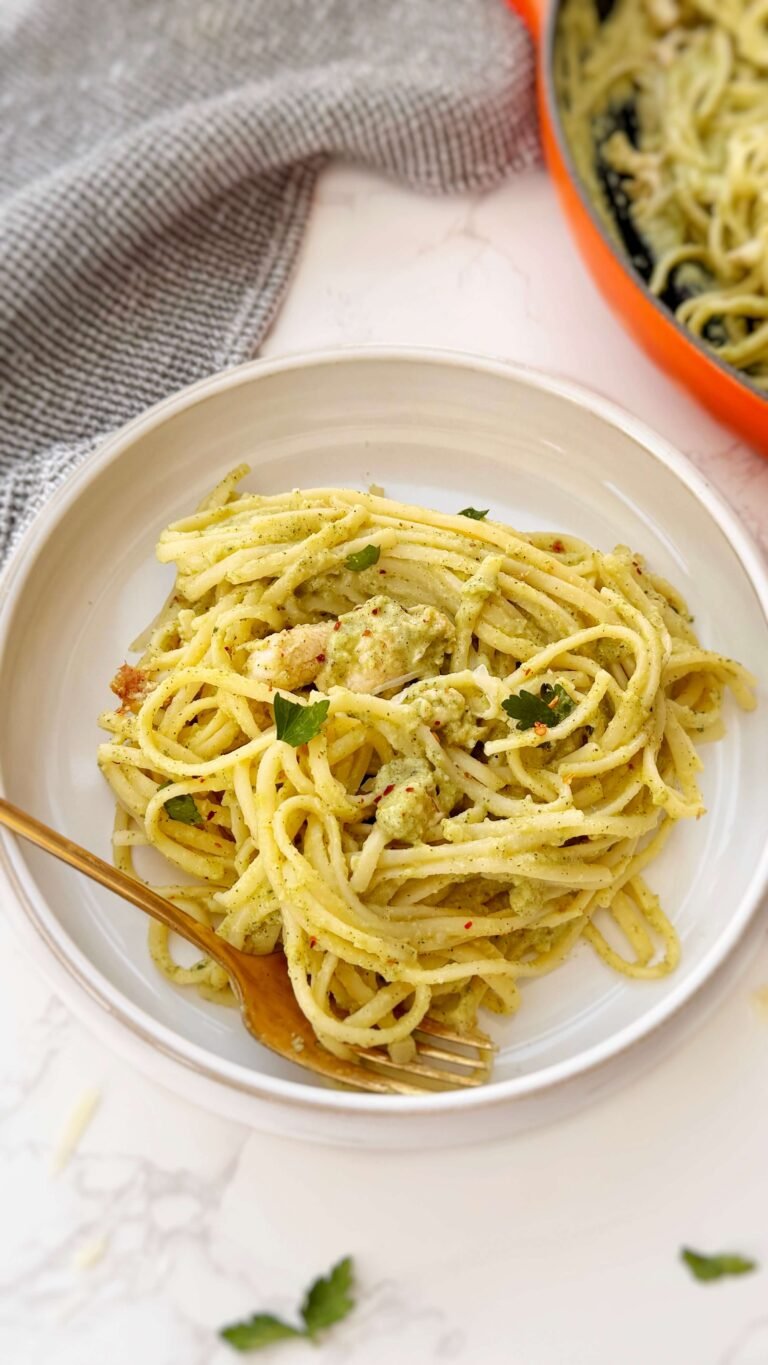 Creamy zucchini and chicken pasta served in a white bowl with fresh parsley garnish