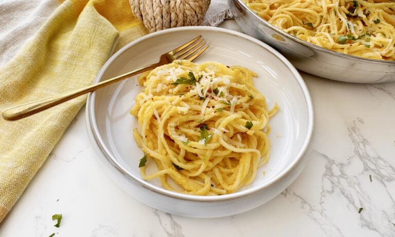 Bowl of creamy roasted pumpkin pasta garnished with parsley