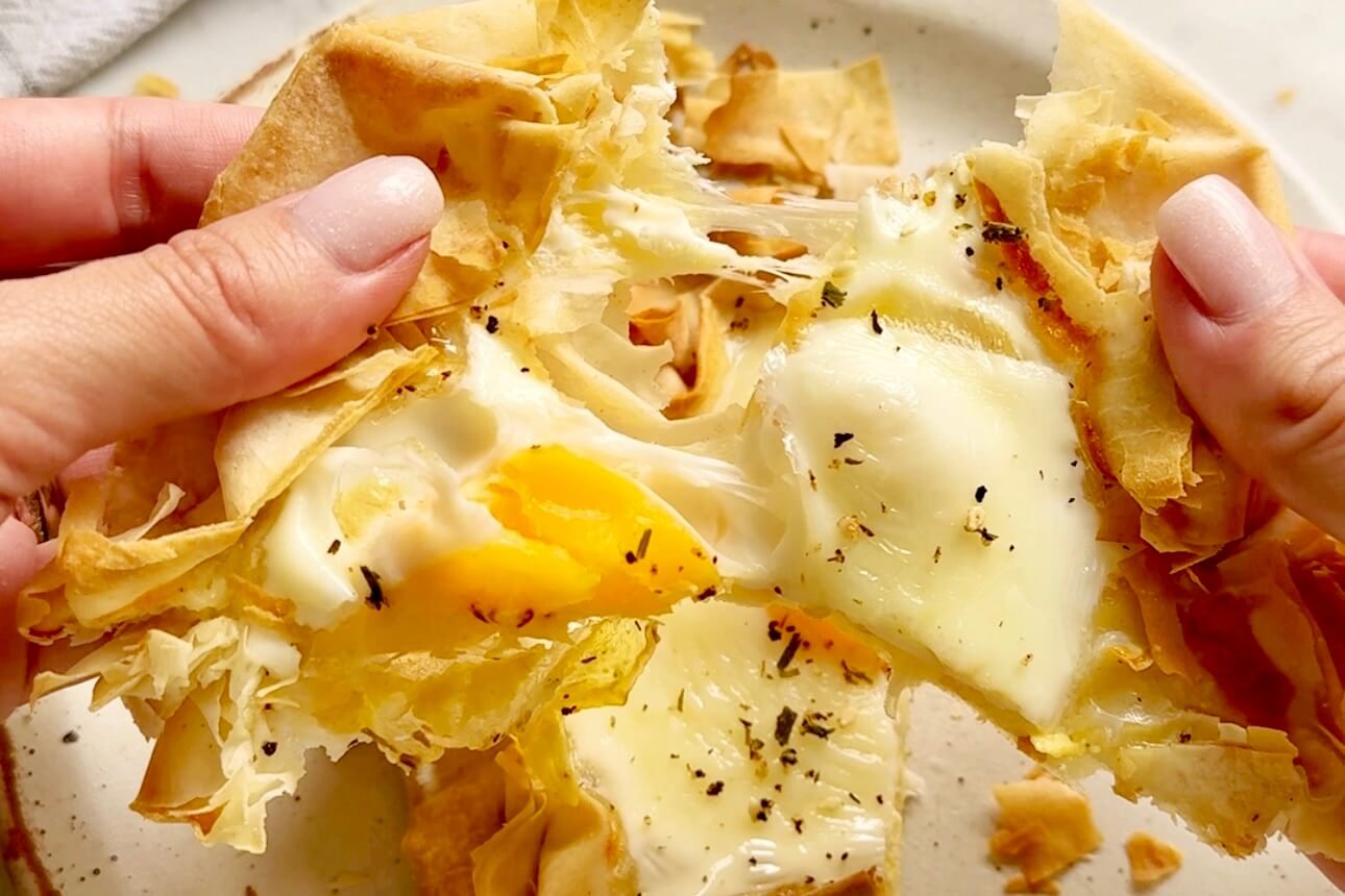 Cheesy Egg Filo Pastry held in hands showing cheese pull