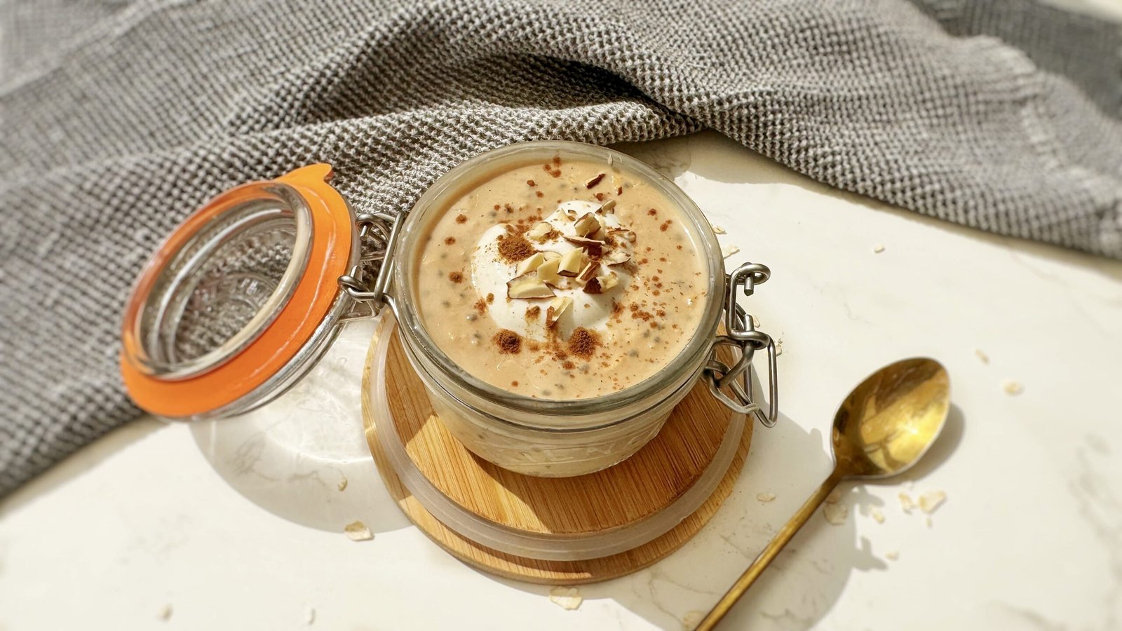 A jar of Pumpkin Spice Latte Overnight Oats topped with cinnamon, showcasing creamy oats with a hint of coffee and fall spices.