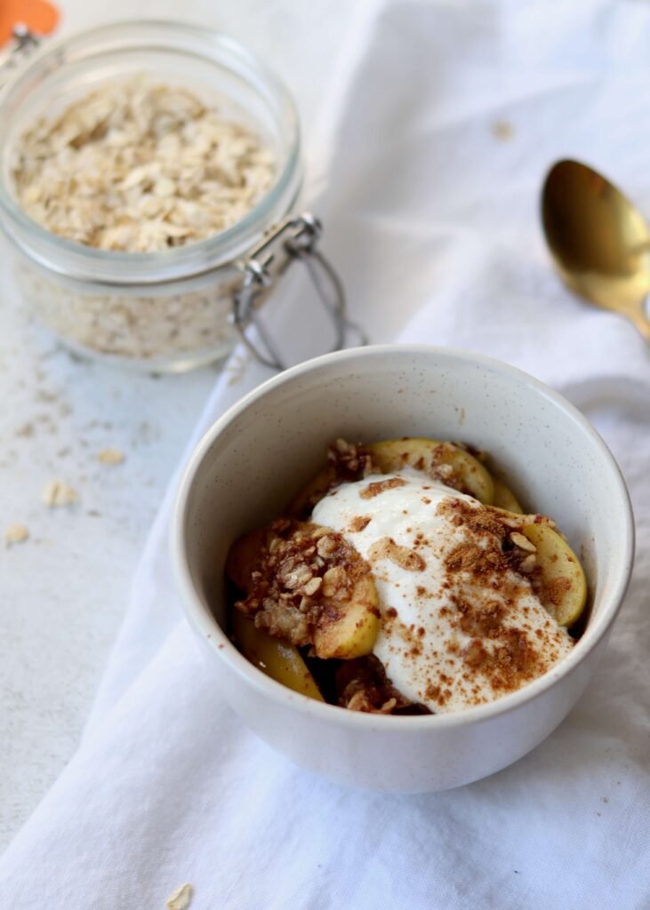 Single serve Skillet Apple Crisp serve in a small bowl topped with yoghurt