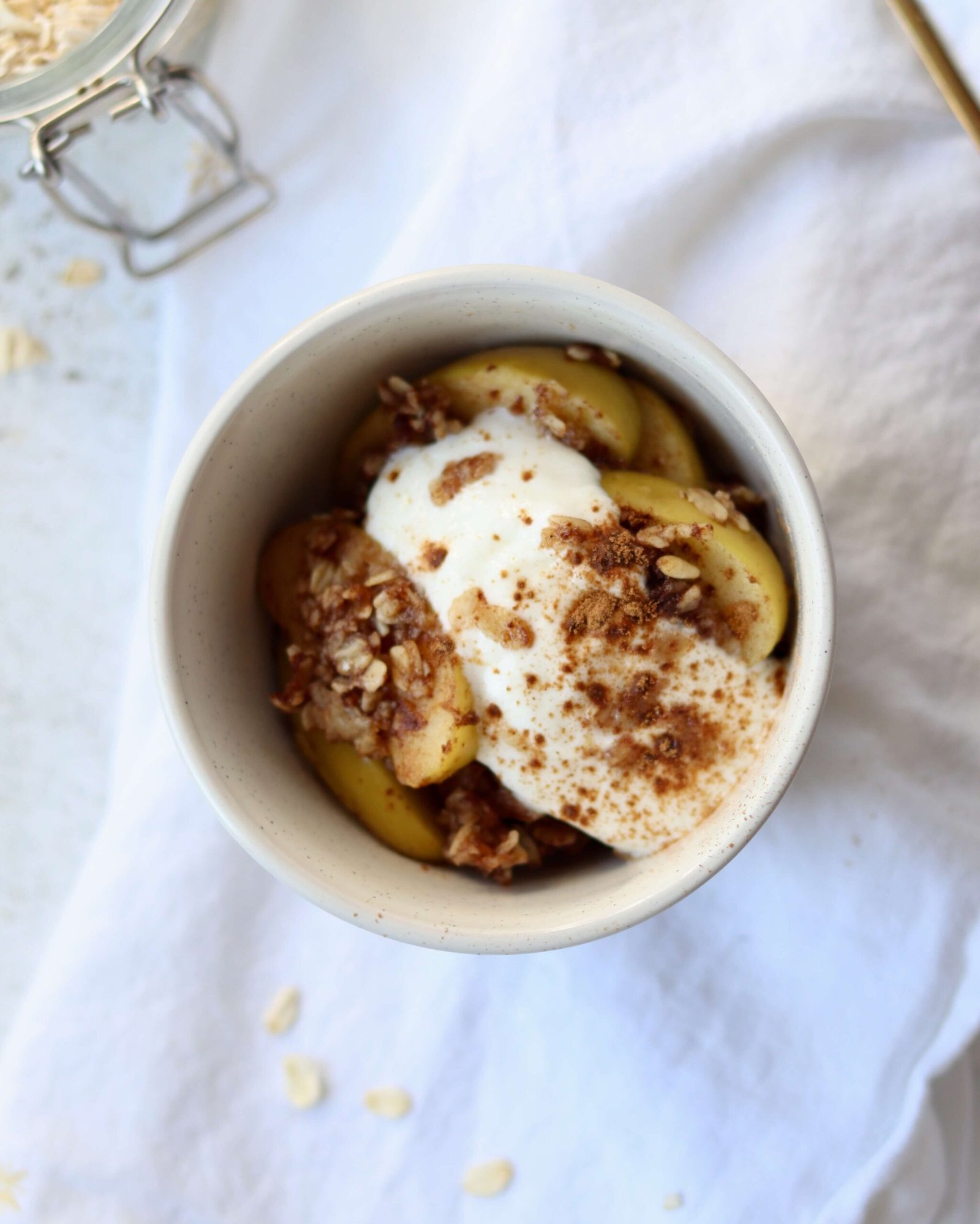 Single serve Skillet Apple Crisp serve in a small bowl topped with yoghurt