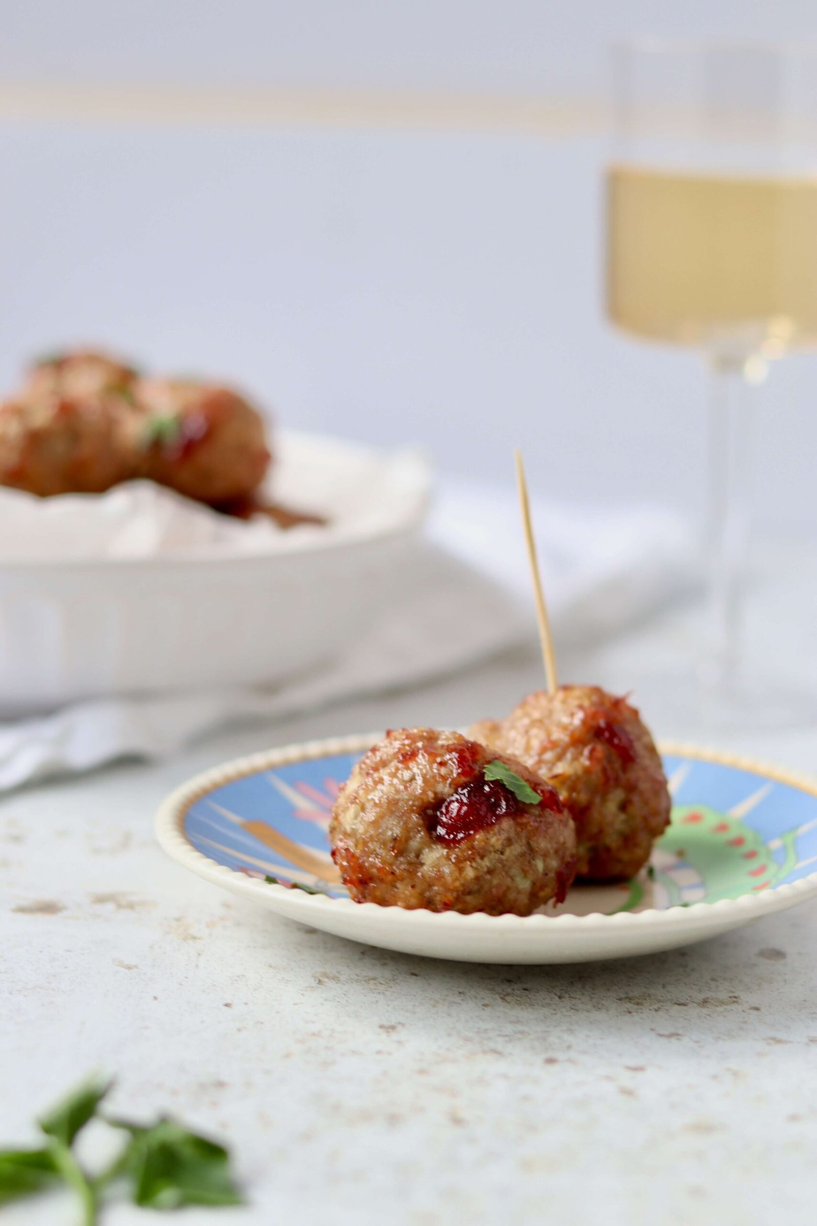 Mini Turkey Meatballs with Cranberry Glaze, two meatballs served on a plate view from side