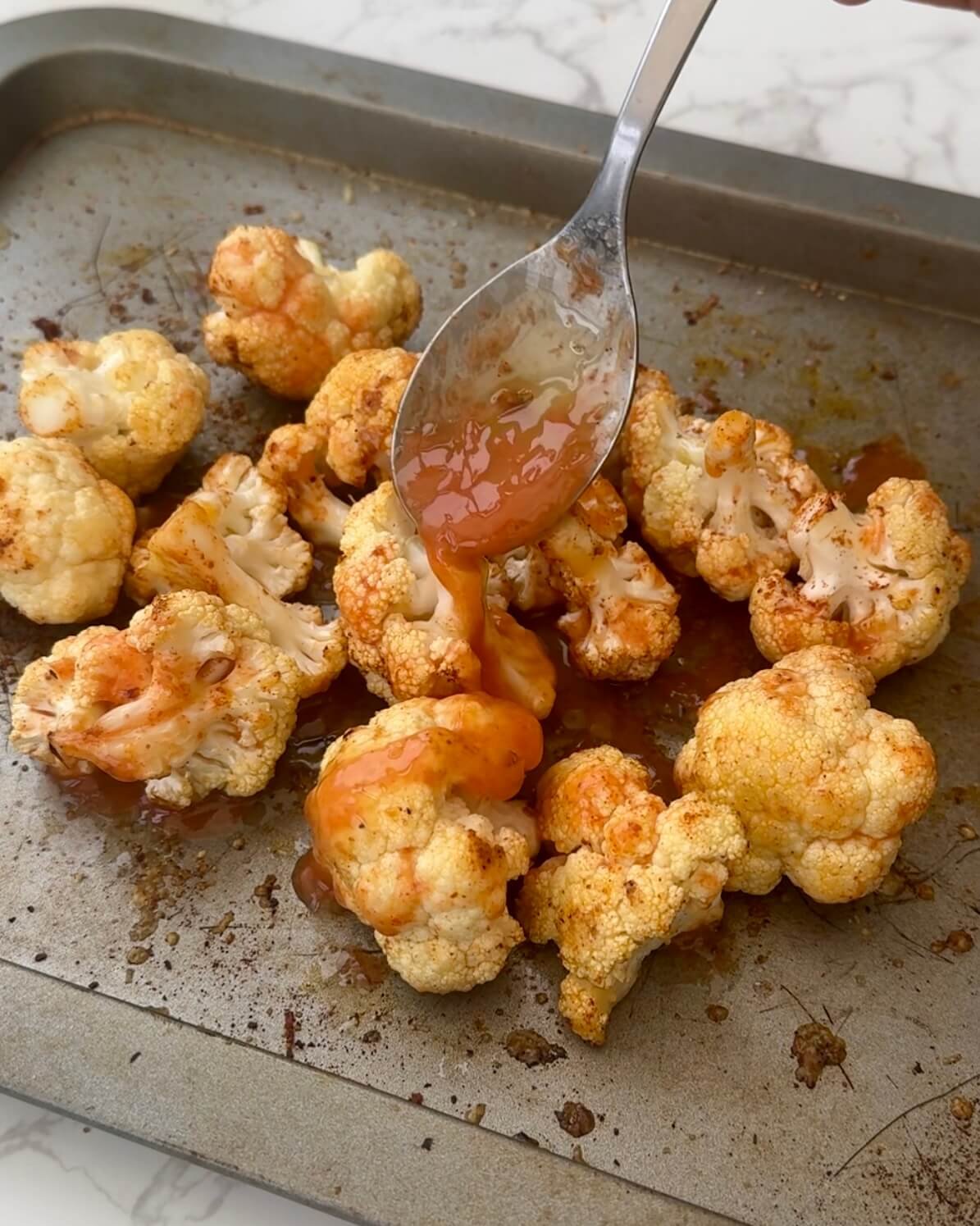 Parmesan Cauliflower Buffalo Bites with Greek Yogurt Ranch, buffalo sauce drizzled