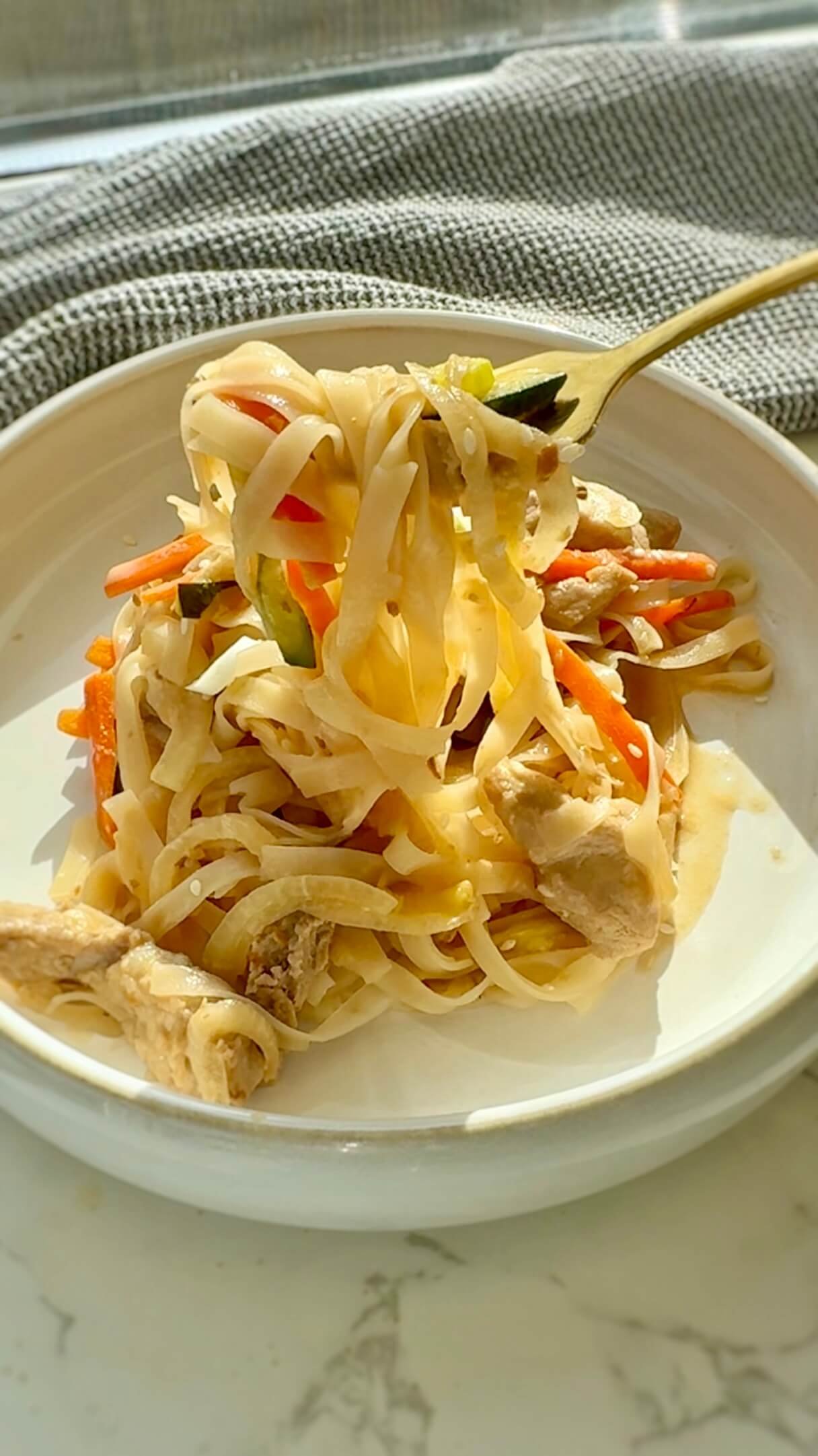 Slow Cooker Creamy Miso Pork Noodles with a fork showing texture