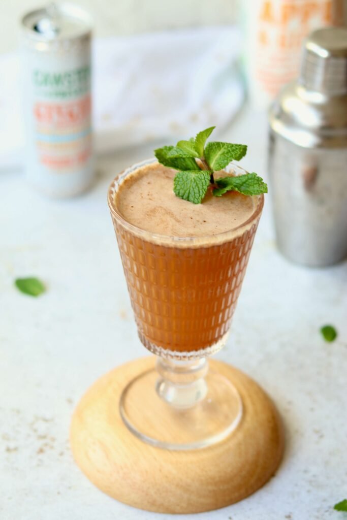 Apple and Ginger Fizz Mocktail, served in glass with mint garnish, closeup