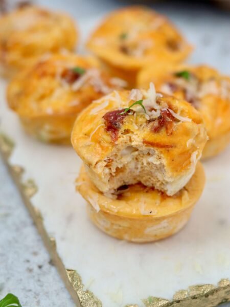 High Protein Cottage cheese egg muffins, two muffins, one has been bitten into showing internal texture