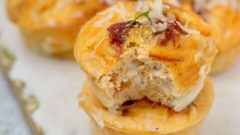 High Protein Cottage cheese egg muffins, two muffins, one has been bitten into showing internal texture