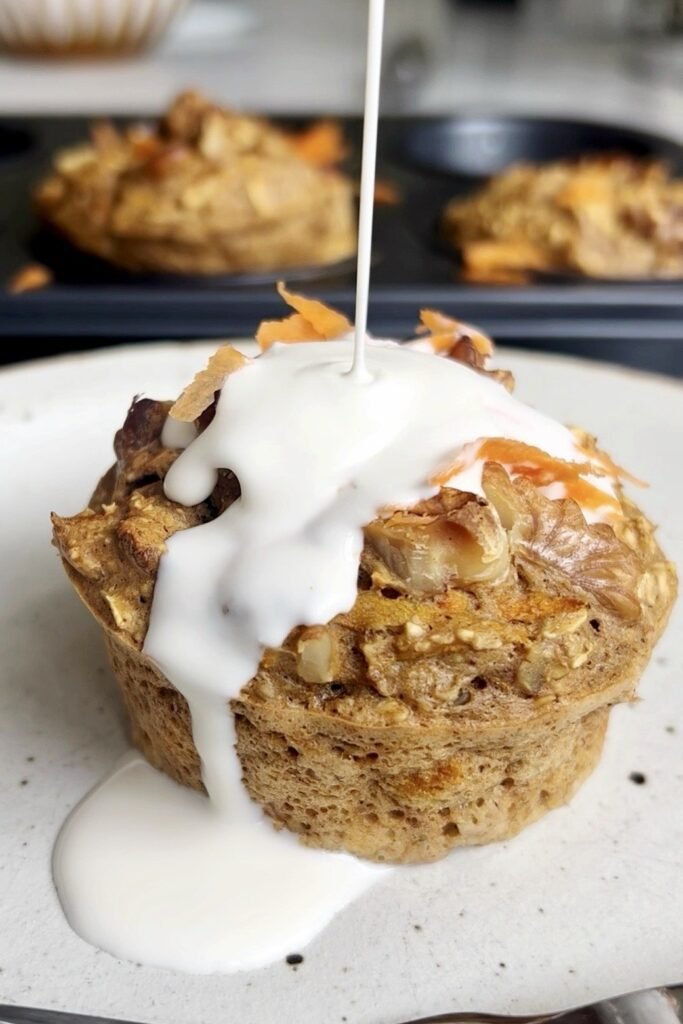 Coconut cream drizzled over a carrot cake breakfast muffin